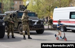 Российские военные на улице в оккупированном Мелитополе. 1 мая 2022 года. Фото: AFP (снимок сделан во время поездки в оккупированный город, организованный армией РФ)