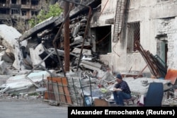 Житель Мариуполя во дворе разрушенного дома. 15 мая 2022 года. Фото: Reuters