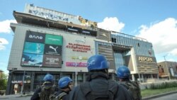 Спасатели возле здания пострадавшего от обстрела торгового центра в Запорожье. 25 мая 2022 года