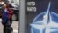 Georgia -- A young woman walks past a poster bearing the NATO logo in Tbilisi, 06May2009