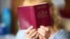 Woman hold a red passport of latvian citizen/Shutterstock