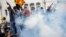 Demonstrators react next to tear gas used by police during a protest demanding the resignation of President Gotabaya Rajapaksa, amid the country's economic crisis, near the president's residence in Colombo, Sri Lanka, July 9, 2022.