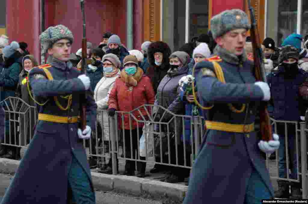 Local residents from a region controlled by a Russia-backed separatist group that calls itself the Donetsk People&#39;s Republic watch an honor guard on January 22 during the ceremony to mark the seventh anniversary of a Donetsk trolleybus being hit by shelling.