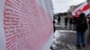Belarus - The Belarusian flag by Marya Gryts with the names of political prisoners (1996-2022) at a rally in Kyiv.