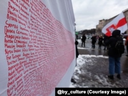 Белорусский флаг с именами политзаключенных. Акция в Киеве, январь 2022 года. Фото: Мария Гриц