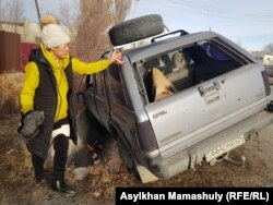 Лаура Нургалиева показывает обстрелянную машину, в которой в Талдыкоргане погиб ее муж