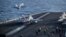 This US Navy handout photo released on May 12, 2026, by US Central Command Public Affairs shows an F/A-18E Super Hornet, attached to Strike Fighter Squadron 151, and an EA-18G Growler, attached to Electronic Attack Squadron 133, launching from the flight 