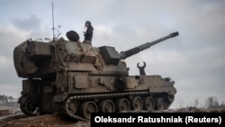 Украинские военнослужащие готовят польскую самоходную гаубицу AHS Krab к обстрелу российских позиций, 17 января 2023