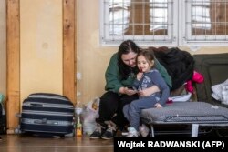 Украинские беженцы сидят на раскладушке в пункте временного размещения беженцев в начальной школе в Перемышле, Восточная Польша, 26 февраля 2022 года