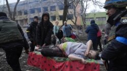UKRAINE – Ukrainian emergency employees and volunteers carry an injured pregnant woman from the damaged by shelling maternity hospital in Mariupol, March 9, 2022