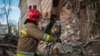 Украинский пожарный работает возле разрушенного жилого дома в Харькове