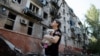 Украинка смотрит на разрушенное ракетным ударом здание в Краматорске 31 августа 2022 года