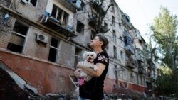 Украинка смотрит на разрушенное ракетным ударом здание в Краматорске 31 августа 2022 года