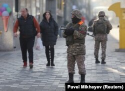 Kazakh service members patrol a street in Almaty on January 12, 2022 following recent protests triggered by a fuel price increase.