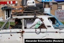 Житель Мариуполя перевозит вещи в автомобиле, 3 мая 2022 года. Фото: Reuters
