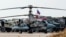 A Russian Air Force Kamov Ka-52 Alligator military attack helicopter is pictured with other trucks and vehicles at the Russian airbase at Qamishli Airport in northeastern Syria on December 12, 2024.