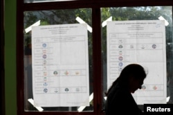 Список партий – участниц выборов возле избирательного участка в Риме. 25 сентября 2022 года. Фото: Reuters
