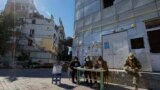 Члены так называемой избирательной комиссии возле разрушенного жилого дома на третий день псевдореферендума о присоединении так называемой "ДНР" к России. Мариуполь, Украина, 25 сентября 2022 года