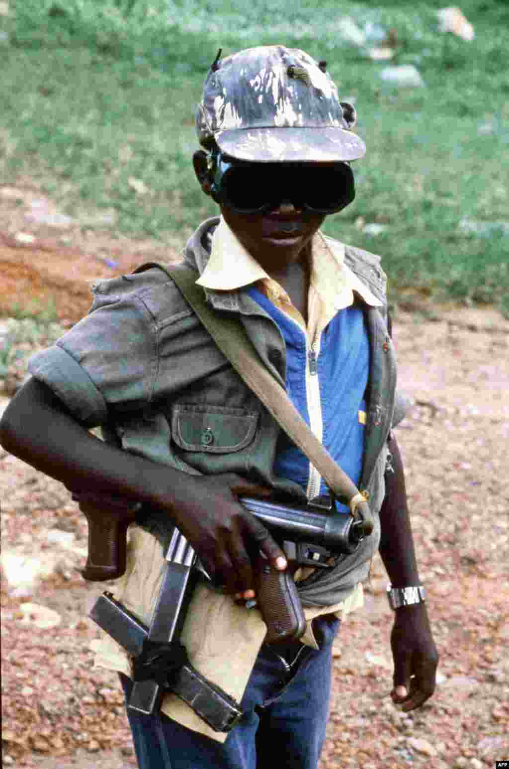 Не менее 30 тысяч детей из Уганды не пойдут в школу в этом году &ndash; их используют в качестве солдат в религиозном конфликте. Похищенным и завербованным мальчикам лидеры разрозненных группировок дают в руки автоматы. Иногда вооружают и девочек, но значительно чаще их используют как секс-рабынь. На фото &ndash; маленький боец партизанской группировки Народная армия сопротивления Уганды