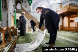 Мужчина раскладывает молельный коврик внутри мечети Муслихудина Чекрекчии в Сараево, Босния и Герцеговина, 6 мая (Ясмин Брутус)