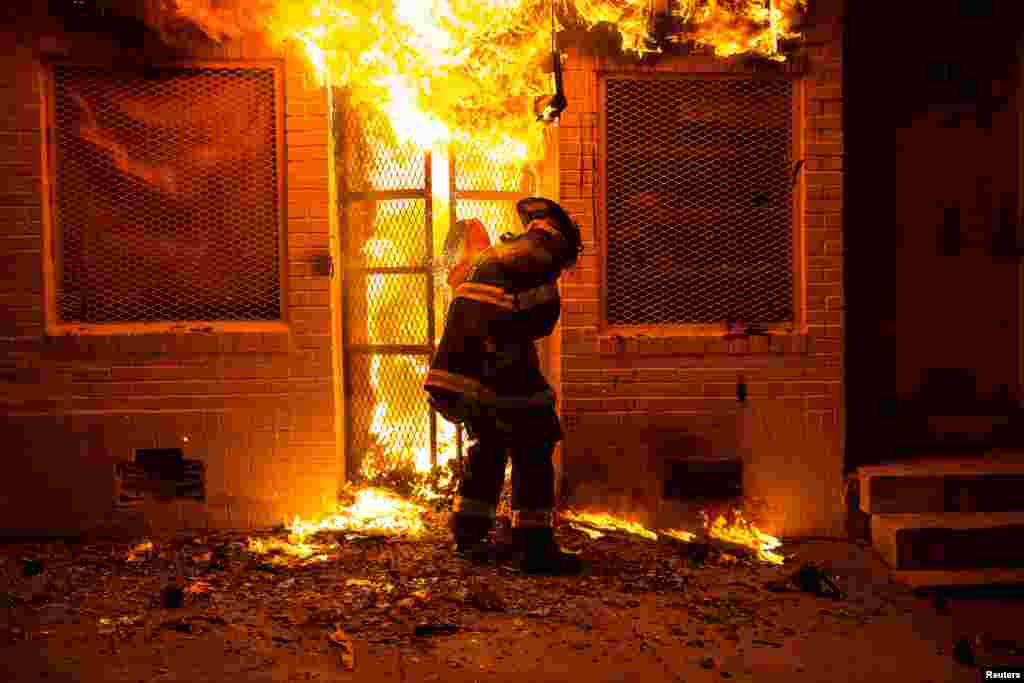 Пожарный пытается справиться с огнем в однном из магазинов Балтимора&nbsp;