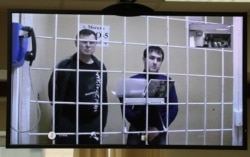 Владимир Калмыков (слева) и Иштимир Худжамов по видеосвязи в суде, март 2018 года. Фото: ТАСС