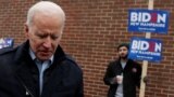 Manchester, New Hampshire, U.S. - A supporter for Democratic 2020 U.S. presidential candidate and former Vice President Joe Biden holds a sign as Biden leaves a polling station after a visit, on the day of New Hampshire's first-in-the-nation primary in Ma
