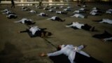 Nurses wearing protective face masks lie on the ground