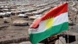 Iraq -- A Kurdish flag flutters in front of the Quru Gusik refugee camp on the outskirts of the city of Irbil in Iraq's Kurdistan region, October 8, 2013. 