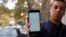 An Iranian man shows his phone while unable to load a social media page as internet service is reportedly disrupted, Tehran, Iran, 17 November 2019.