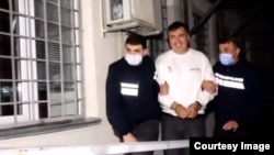 Video footage released by the Georgian Interior Ministry on October 1 showed a handcuffed Mikheil Saakashvili being escorted by police into an unidentified building. 
