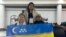 Каракалпакские активисты Раиса Худайбергенова (слева), Тлеубике Юлдашева и Жангельды Жаксымбетов с флагом Каракалпакстана в США. 15 октября 2024 года
