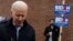 Manchester, New Hampshire, U.S. - A supporter for Democratic 2020 U.S. presidential candidate and former Vice President Joe Biden holds a sign as Biden leaves a polling station after a visit, on the day of New Hampshire's first-in-the-nation primary in Ma