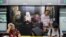 MALAYSIA – Commuters sit in front of an advertisement discouraging the dissemination of fake news, at a train station in Kuala Lumpur