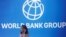 A participant stands near a logo of World Bank 