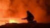 A firefighter works to extinguish a fire at the site of a drone attack late night in Kharkiv on September 23, 2025, amid the Russian invasion of Ukraine. (Photo by SERGEY BOBOK / AFP)