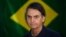 BRAZIL -- Brazil's right-wing presidential candidate for the Social Liberal Party (PSL) Jair Bolsonaro gestures in front of the Brazilian flag as he prepares to cast his vote during the general elections, in Rio de Janeiro, October 7, 2018