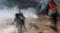 Palestine -- Palestinian demonstrators run for cover during a protest against U.S. embassy move to Jerusalem and ahead of the 70th anniversary of Nakba, at the Israel-Gaza border in the southern Gaza Strip May 14, 2018