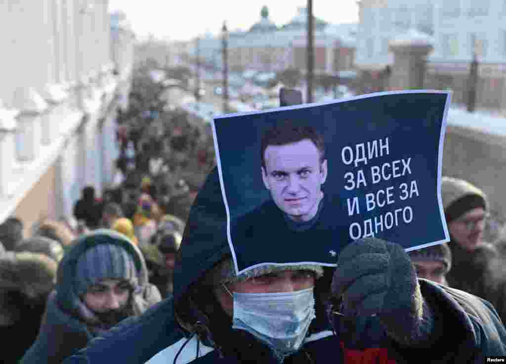 In Omsk, a man holds a placard with Aleksei Navalny&#39;s photo and the slogan &quot;All for one and one for all.&quot;&nbsp;