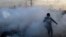 Palestine -- Palestinian press photographers run amidst tear gas smoke during clashes with Israeli forces on December 11, 2017 near the border fence with Israel, east of Gaza City.