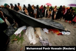 Толпа на берегу реки в Бангладеш смотрит на тела беженцев-рохинджа, утонувших ночью при переправе. 1 сентября