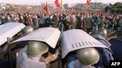 Сотрудники ОМОНа прикрываются щитами, пытаясь остановить шествие сторонников Верховного совета во время противостояния октября 1993 года