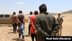 Предполагаемые боевики "Исламского государства", взятые в плен альянсом курдских и арабских сил в Сирии. Местность недалеко от Манбиджа, 31 мая 2016 года.