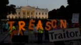 U.S. -- Activists hold letters reading the word "Treason" in front of the White House during a sunset demonstration to denounce the link between the 2016 Trump campaign and Russia, in Washington, July 29, 2018