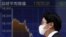 Japan -- A pedestrian walks past an electronic board showing the graph of the recent fluctuations of Japan's Nikkei average outside a brokerage in Tokyo, Japan, 07Jan2016