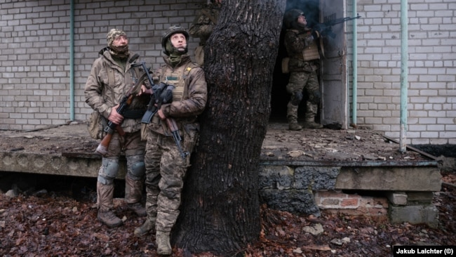 Француз (слева) и Сява (опирается на дерево) наблюдают за дроном во время тренировки