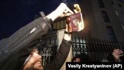 С начала полномасштабного вторжения России в Украину в Грузии проходили массовые протесты. На фото – один из протестующих сжигает свой российский паспорт