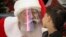 RUSSIA - An actor dressed as Santa Claus and wearing a face mask to protect against coronavirus infection speaks with a boy during the New Year celebration in a shopping mall in St.Petersburg, Russia, Saturday, Jan. 2, 2021