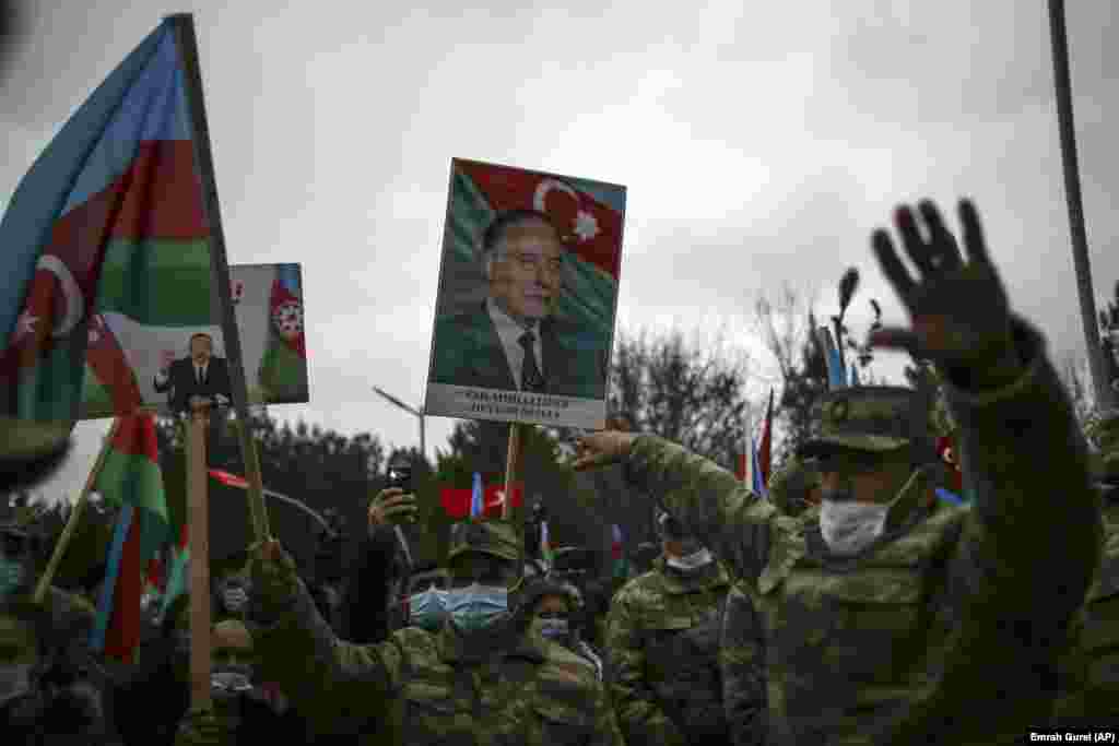 Azerbaijani soldiers hold national flags and portraits of Azerbaijani President Ilham Aliyev, left, and his father, the late President Heydar Aliyev, as they celebrate the return of the Lachin district to Azerbaijan&#39;s control on December 1, 2020. The region, which neighbors breakaway Nagorno-Karabakh, had been under Armenian control since May 1992.&nbsp;