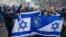 Supporters of Maccabi Tel Aviv hold flags at Dam square ahead of the Europa League football match between Ajax and Maccabi Tel Aviv, in Amsterdam on November 7, 2024. (Photo by Jeroen Jumelet / ANP / AFP) / NETHERLANDS OUT
